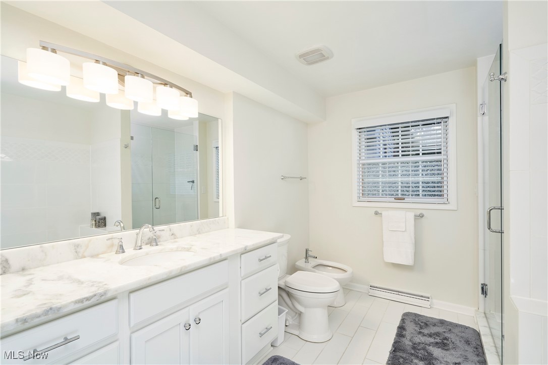 2285 Lancaster Road Akron, OH 44313 - Photo 24 of 48 Full bathroom with vanity, a bidet, a stall shower, baseboard heating, and light tile patterned flooring
