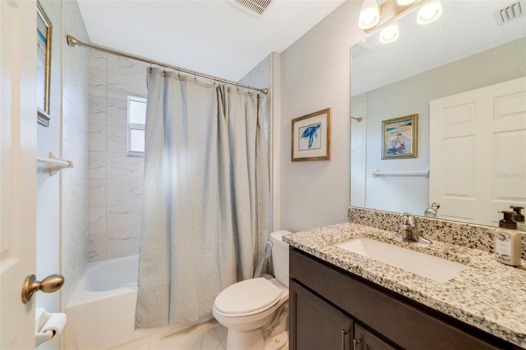 1239 St Anne Shrine Road Lake Wales, FL 33898 - Photo 12 of 27 a bathroom with a granite countertop sink toilet and shower