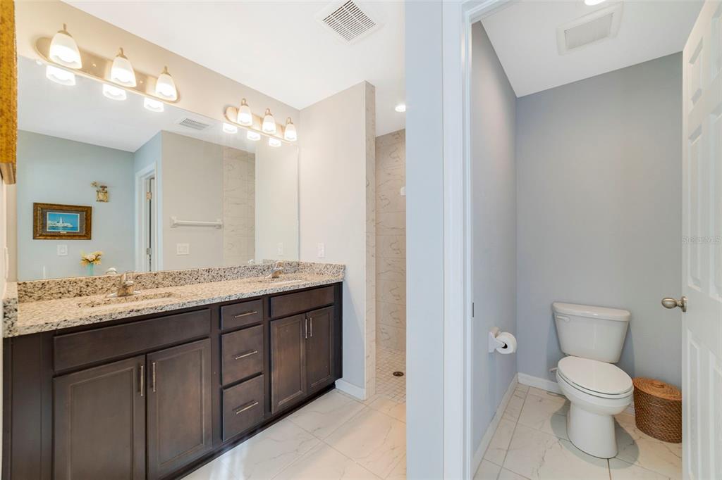 1239 St Anne Shrine Road Lake Wales, FL 33898 - Photo 9 of 27 a bathroom with a granite countertop sink a toilet and a mirror