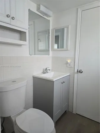 a bathroom with a toilet a sink and mirror