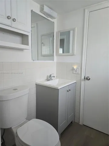 a bathroom with a toilet a sink and mirror