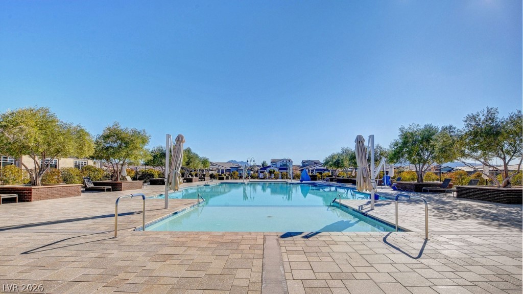 498 Pebble Run Avenue Henderson, NV 89011 - Photo 35 of 47 An inviting outdoor pool with a paver deck, perfect for relaxation and recreation.