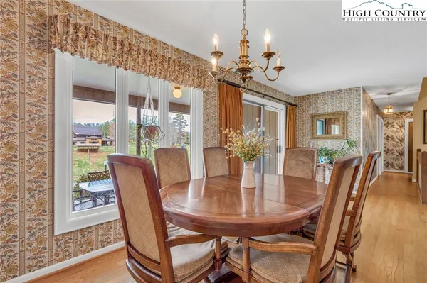 a view of a dining room with furniture a chandelier and wooden floor