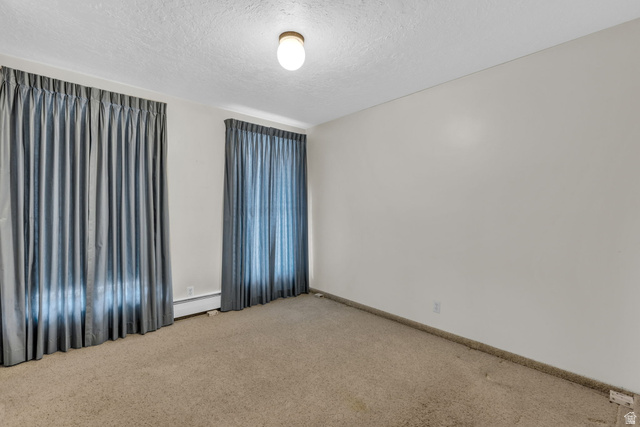 10705 Green Ridge Drive Sandy, UT 84070 - Photo 27 of 55 Unfurnished room with a textured ceiling, light colored carpet, and a baseboard radiator