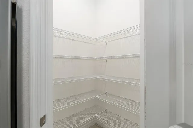 a view of walk in closet with empty racks