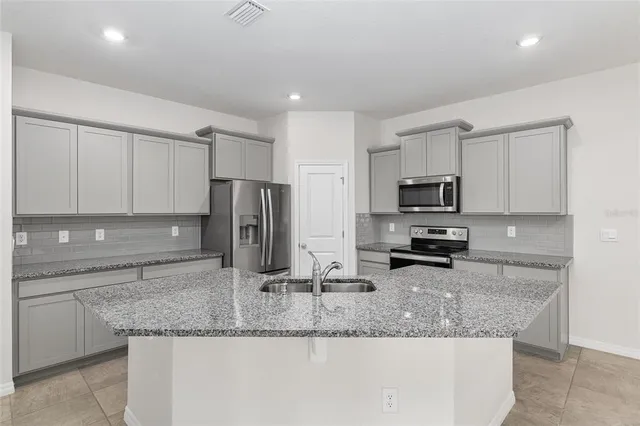 a kitchen with stainless steel appliances granite countertop a sink a microwave counter space and cabinets