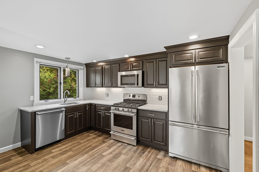 116 Hartwick Street Springfield, MA 01108 - Photo 15 of 38 a kitchen with stainless steel appliances granite countertop a stove a refrigerator and a sink with wooden cabinets