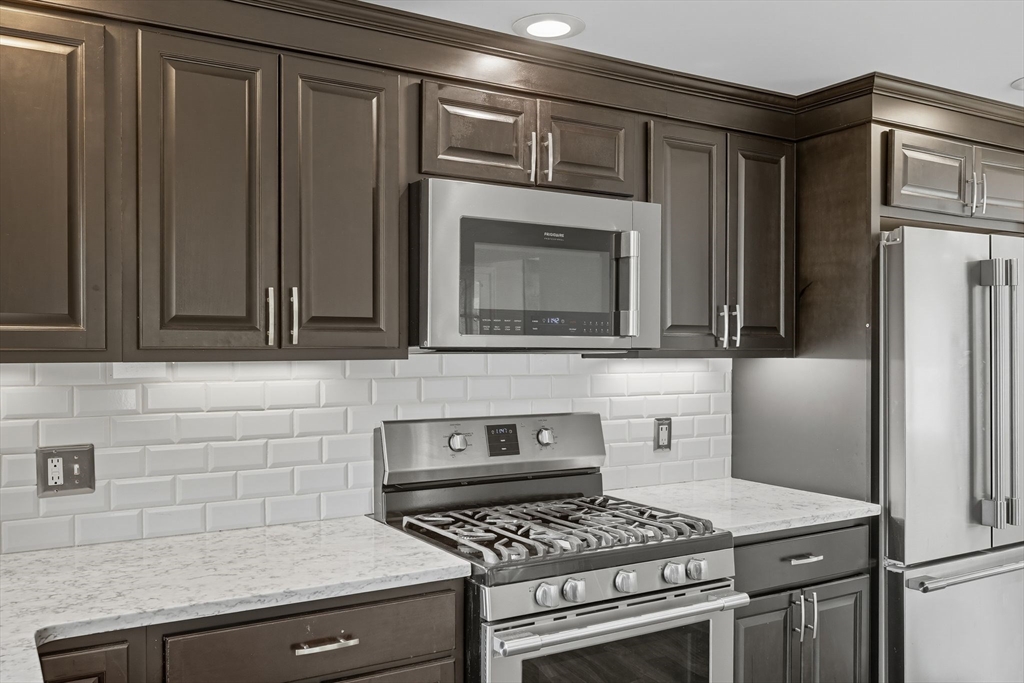 116 Hartwick Street Springfield, MA 01108 - Photo 19 of 38 a kitchen with stainless steel appliances wooden cabinets and a stove top oven