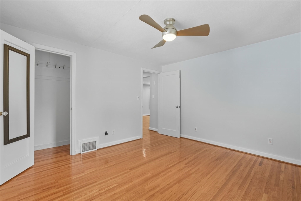 116 Hartwick Street Springfield, MA 01108 - Photo 21 of 38 an empty room with wooden floor and a ceiling fan