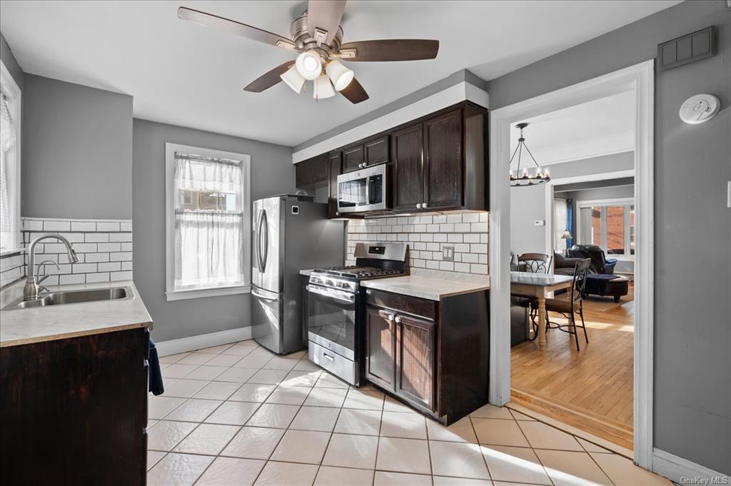 1076 Rhinelander Avenue Bronx, NY 10461 - Photo 6 of 31 a kitchen with stainless steel appliances granite countertop a stove refrigerator and a sink