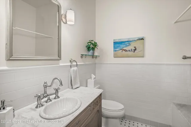 a bathroom with a toilet a sink and a mirror