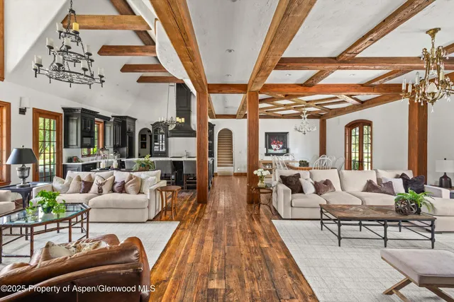 a living room with furniture fireplace and floor to ceiling windows