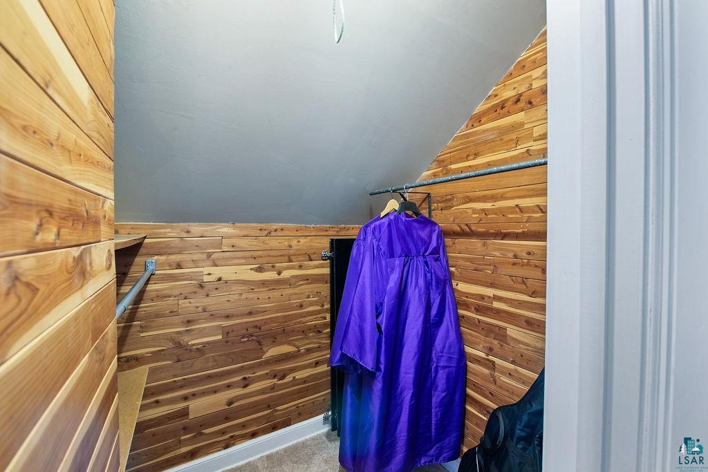 122 3rd Street Cloquet, MN 55720 - Photo 20 of 42 Cedar-lined closet featuring sloped ceiling, carpet flooring, and a metal hanging rod