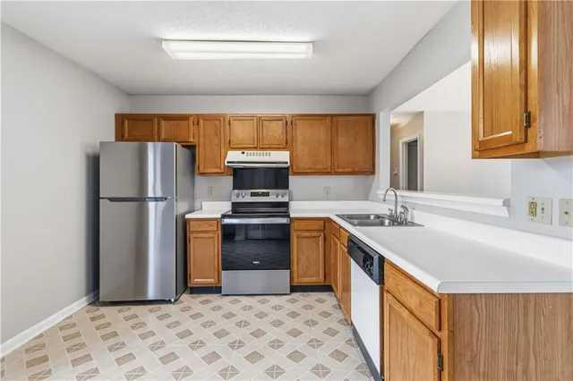 a kitchen with stainless steel appliances granite countertop a refrigerator a stove a sink and a microwave