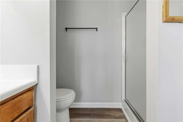 a bathroom with a granite countertop toilet and a shower