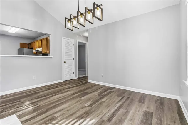 a view of a room with wooden floor and ceiling fan