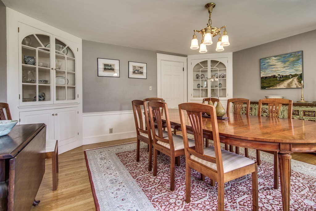 23 Slough Road Harvard, MA 01451 - Photo 11 of 30 a dining room with wooden floor a chandelier a wooden table and chairs