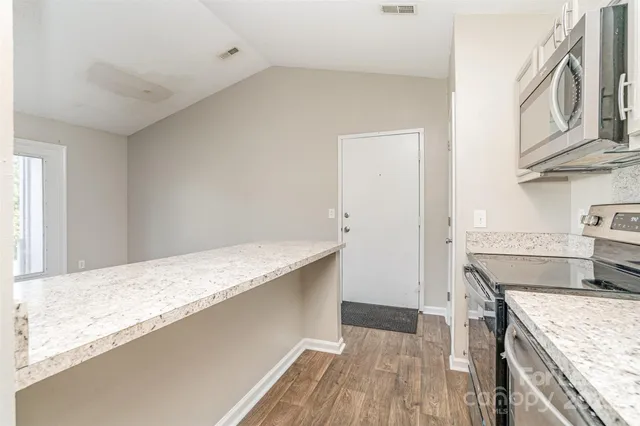a kitchen with granite countertop a sink and a stove