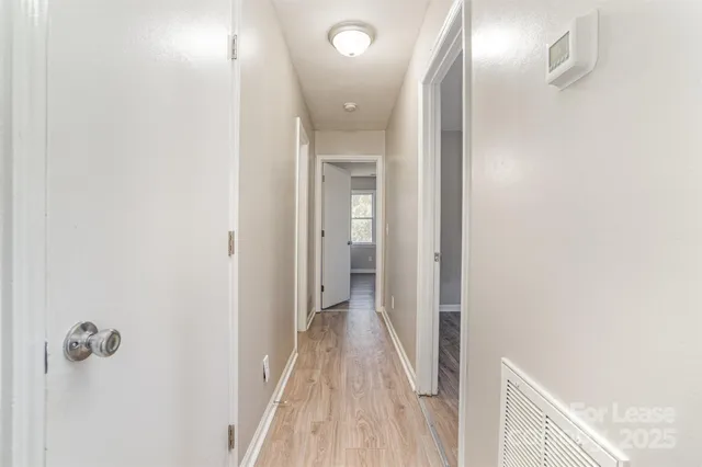 a view of a hallway with wooden floor