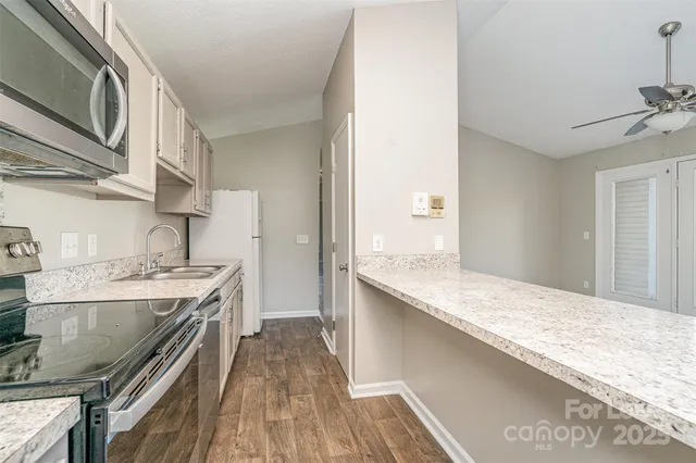 a kitchen with stainless steel appliances granite countertop a lot of counter space and wooden floor