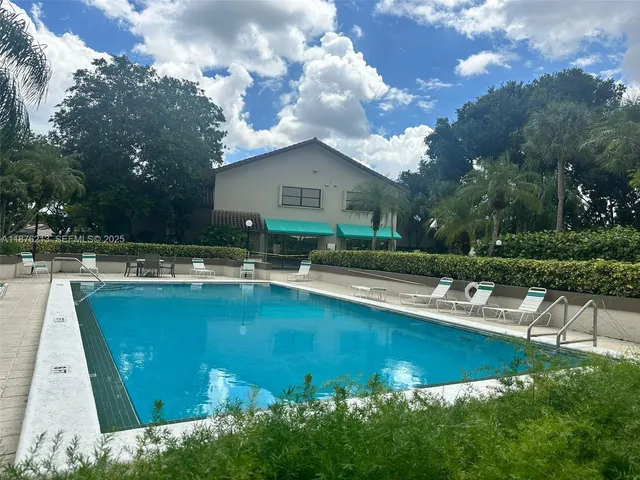 a view of a house with swimming pool and sitting area