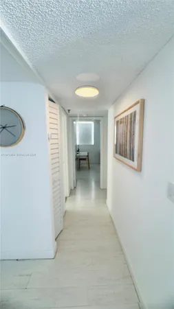 a view of a hallway with furniture and a window