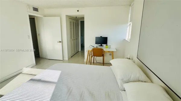 a living room with a bed furniture and a flat screen tv