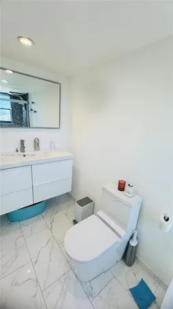 a bathroom with a sink toilet and mirror