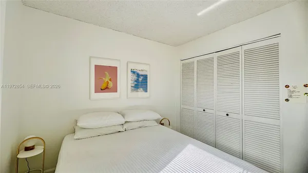 a bedroom with a bed and a painting on the wall
