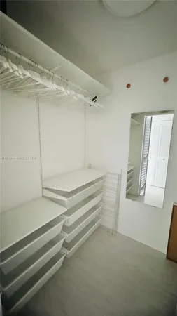 a view of walk in closet with empty racks
