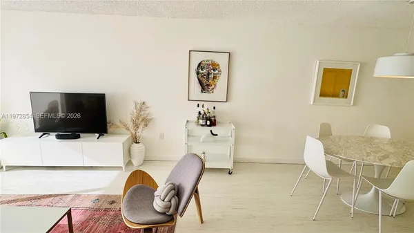 a work room with furniture a flat screen tv and a window