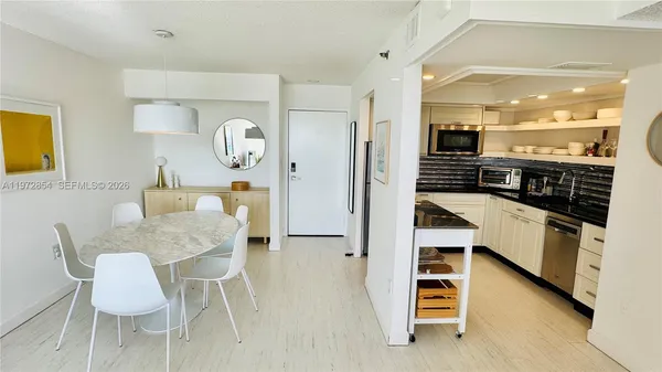 a kitchen with a table chairs and a refrigerator