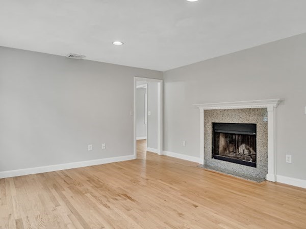 71 Smith Street Wellesley, MA 02482 - Photo 3 of 25 a view of an empty room with wooden floor fireplace and a window