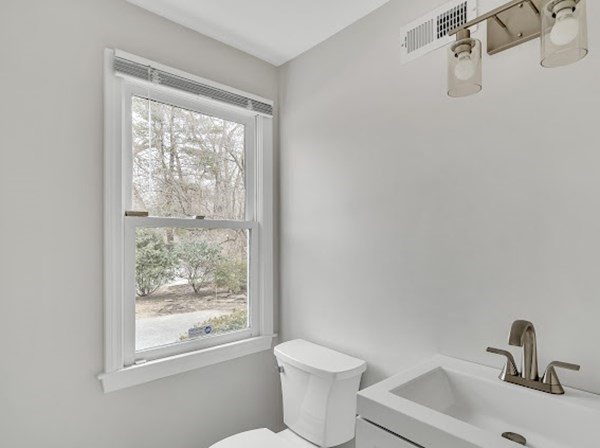 71 Smith Street Wellesley, MA 02482 - Photo 7 of 25 a bathroom with a toilet sink a window and mirror