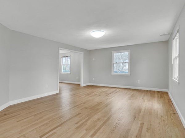 71 Smith Street Wellesley, MA 02482 - Photo 8 of 25 an empty room with wooden floor and windows