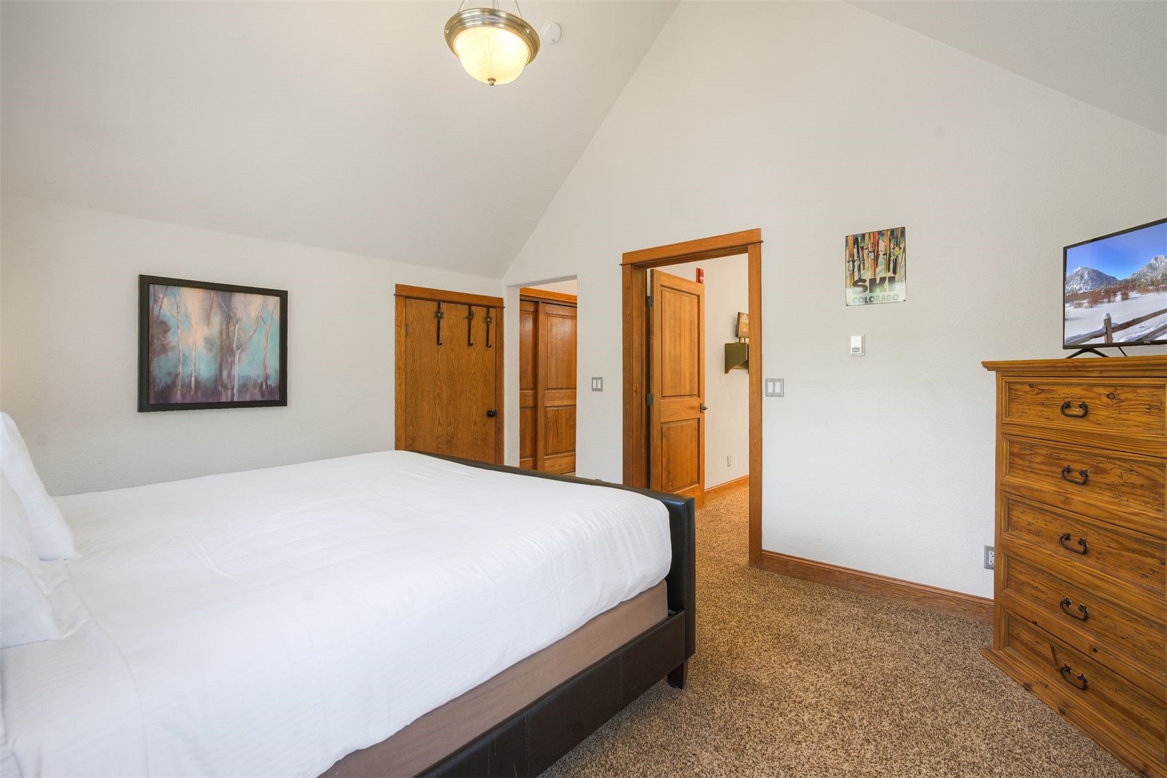 71 Antlers Gulch Road, Unit 303 Keystone, CO 80435 - Photo 23 of 35 a bedroom with a bed and a dresser
