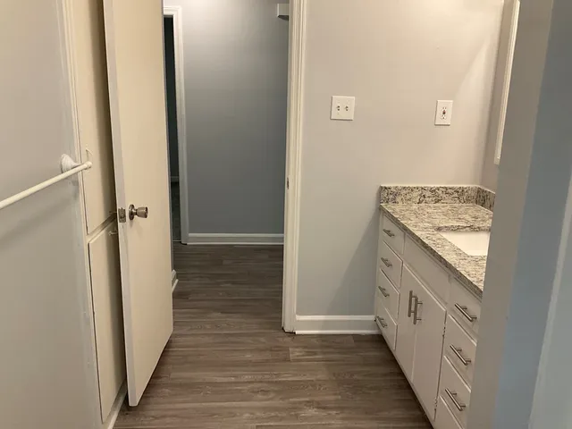 a bathroom with a granite countertop sink and washing machine