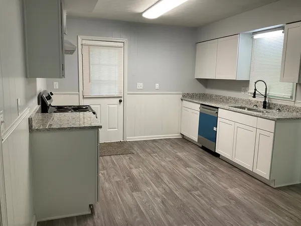 a kitchen with granite countertop a sink and cabinets