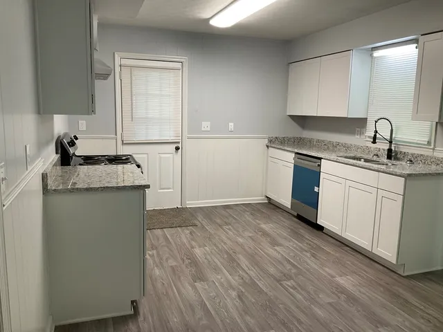 a kitchen with granite countertop a sink and cabinets