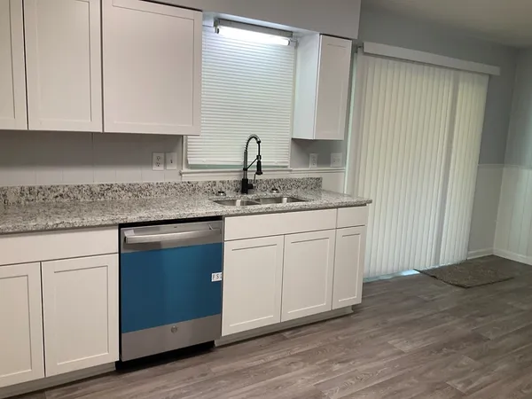 a kitchen with stainless steel appliances granite countertop a sink and dishwasher with wooden floor