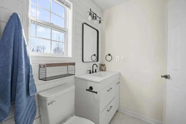 a bathroom with a sink a toilet and a mirror