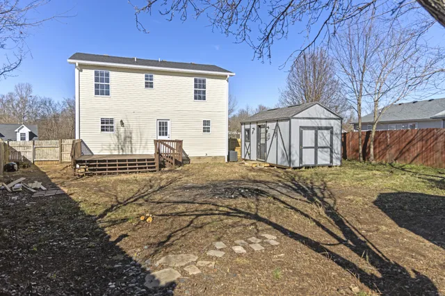 a view of a house with backyard and a tree
