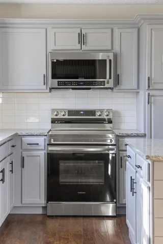 a kitchen with stainless steel appliances a stove a microwave and sink