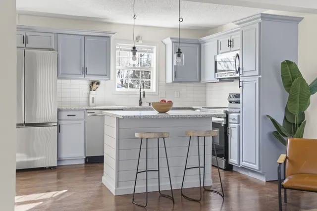 a kitchen with a sink a stove a refrigerator and cabinets