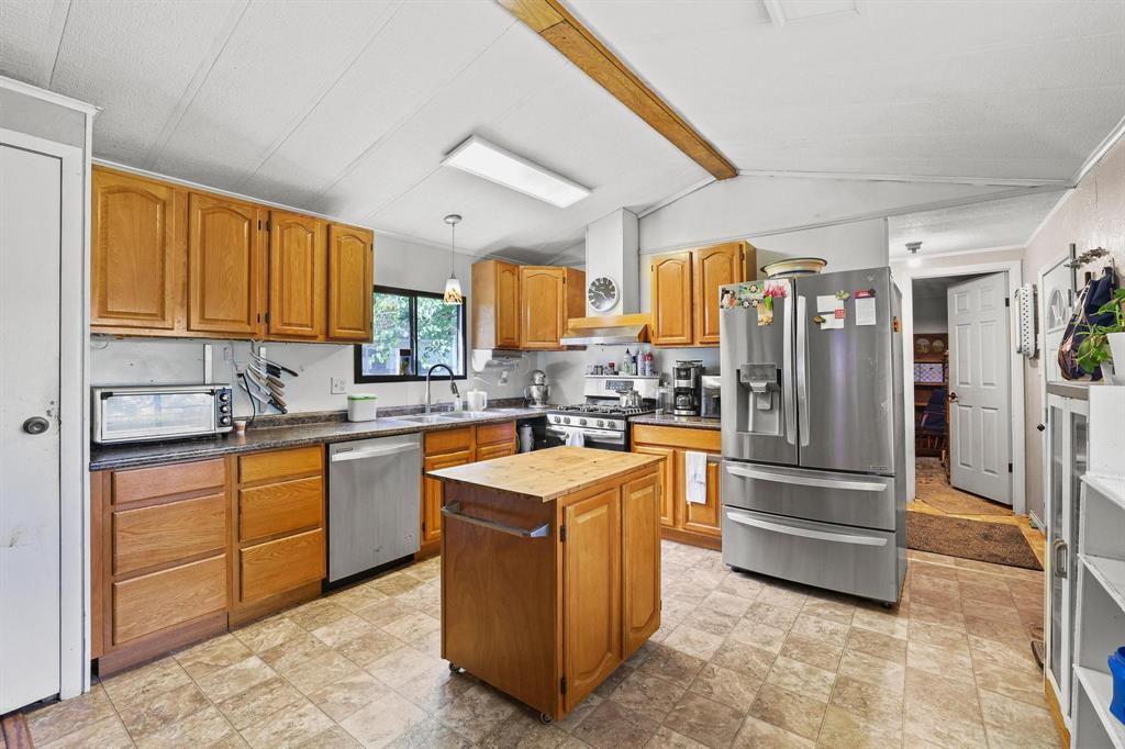 252 Meadow Lake Estates Road Denison, TX 75021 - Photo 8 of 37 Kitchen with built in cabinets, prep island and stainless steel appliances.