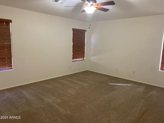 an empty room with a chandelier fan