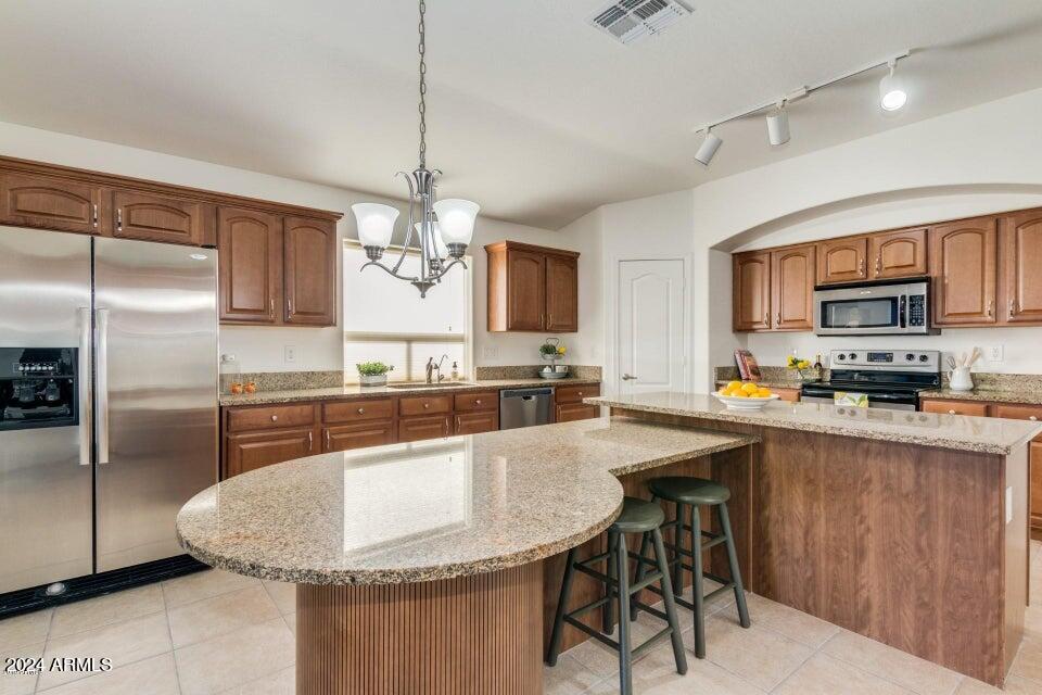 2812 East Questa Drive Phoenix, AZ 85024 - Photo 5 of 32 a large kitchen with kitchen island a large counter top space a sink stainless steel appliances and cabinets