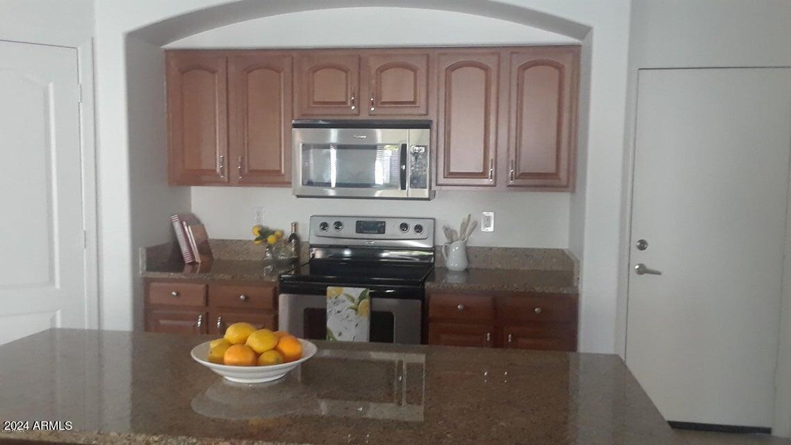 2812 East Questa Drive Phoenix, AZ 85024 - Photo 6 of 32 a kitchen with stainless steel appliances granite countertop a stove and a refrigerator