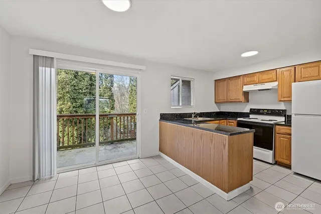 a kitchen with stainless steel appliances granite countertop a stove a sink and a refrigerator