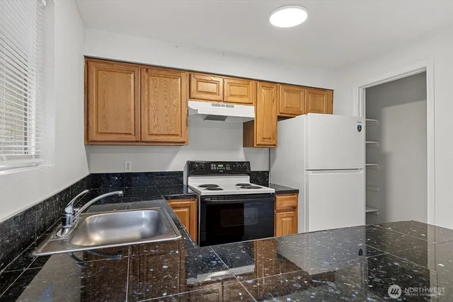 a kitchen with a stove a refrigerator and a sink